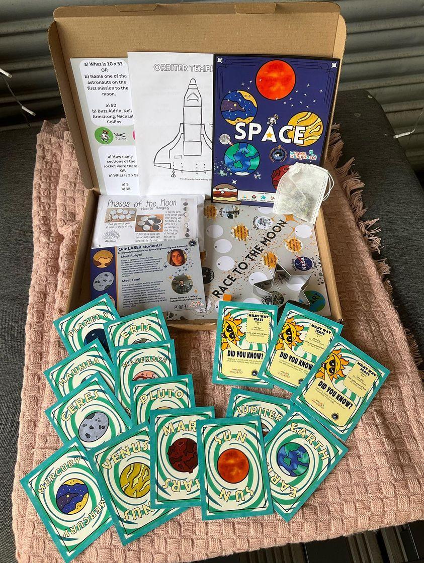 Inside the space activities box for kids. A space-themed activity box brimming with captivating resources.